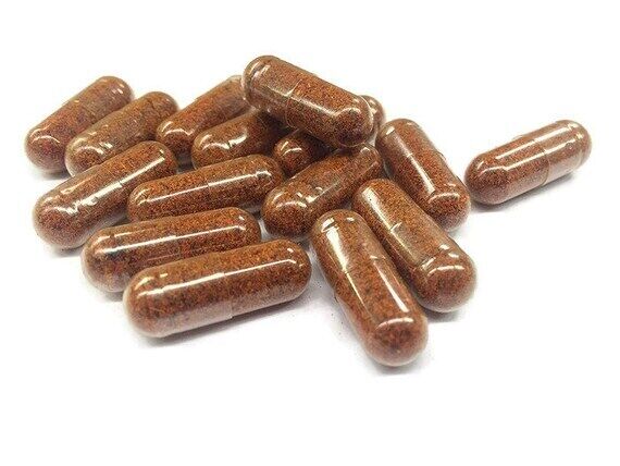 A pile of brown capsules with a speckled texture, representing organic supplements containing cayenne, ginger, and hawthorn berry.